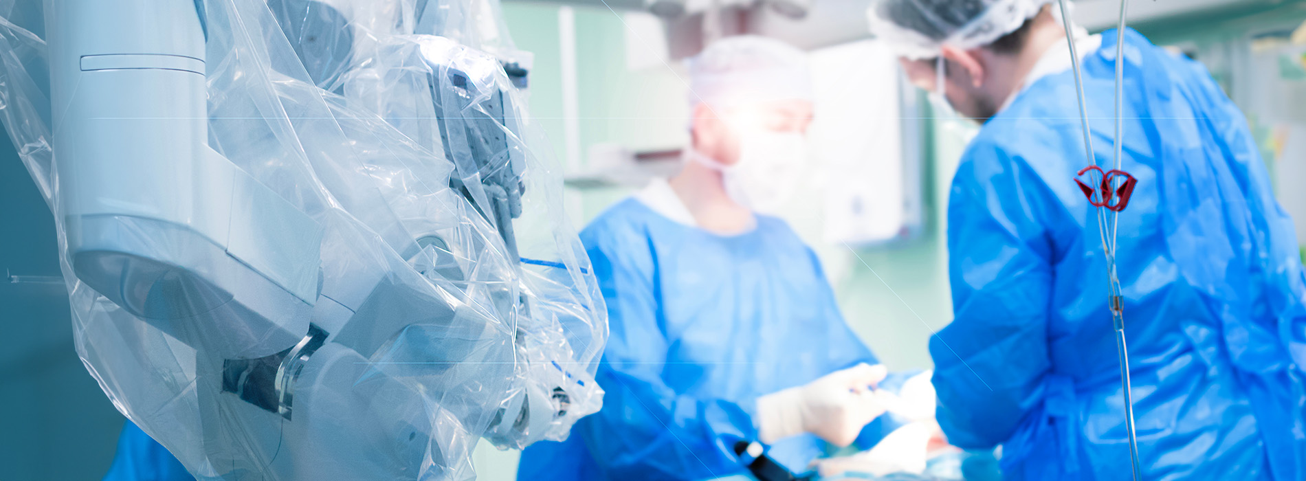 The image depicts a medical setting with personnel in protective gear, including surgical masks and gowns, attending to equipment and a patient, likely in an operating room.
